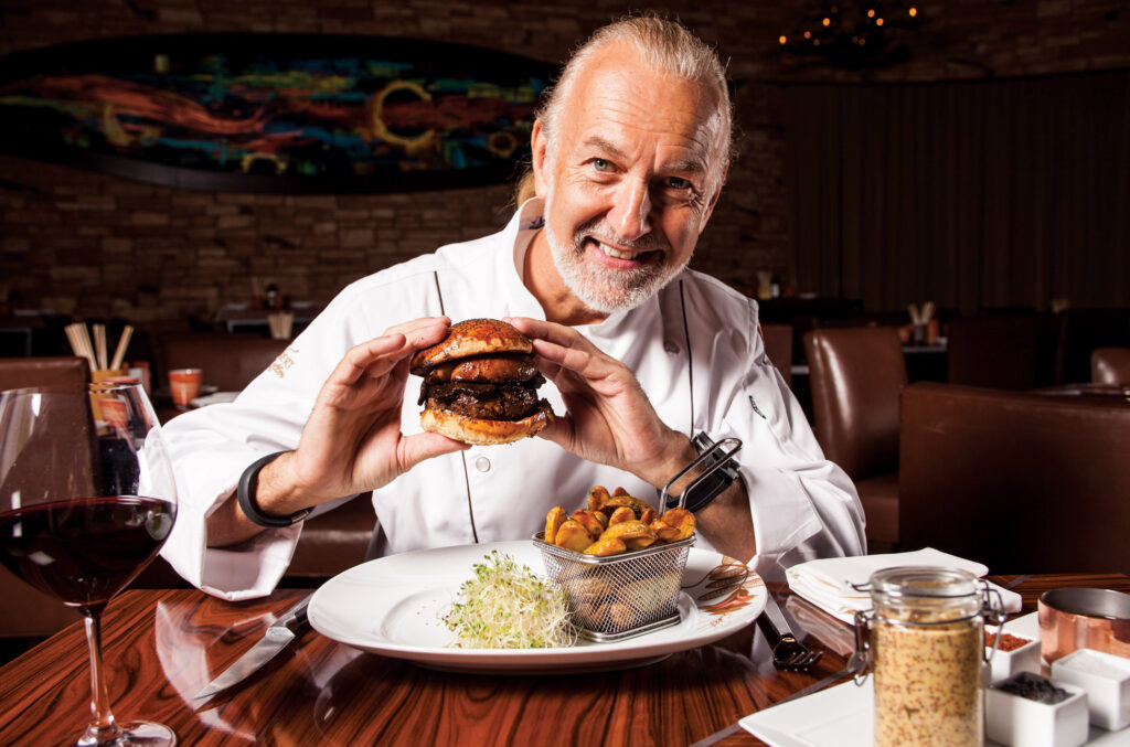 Chef Hubert Keller holding a burger